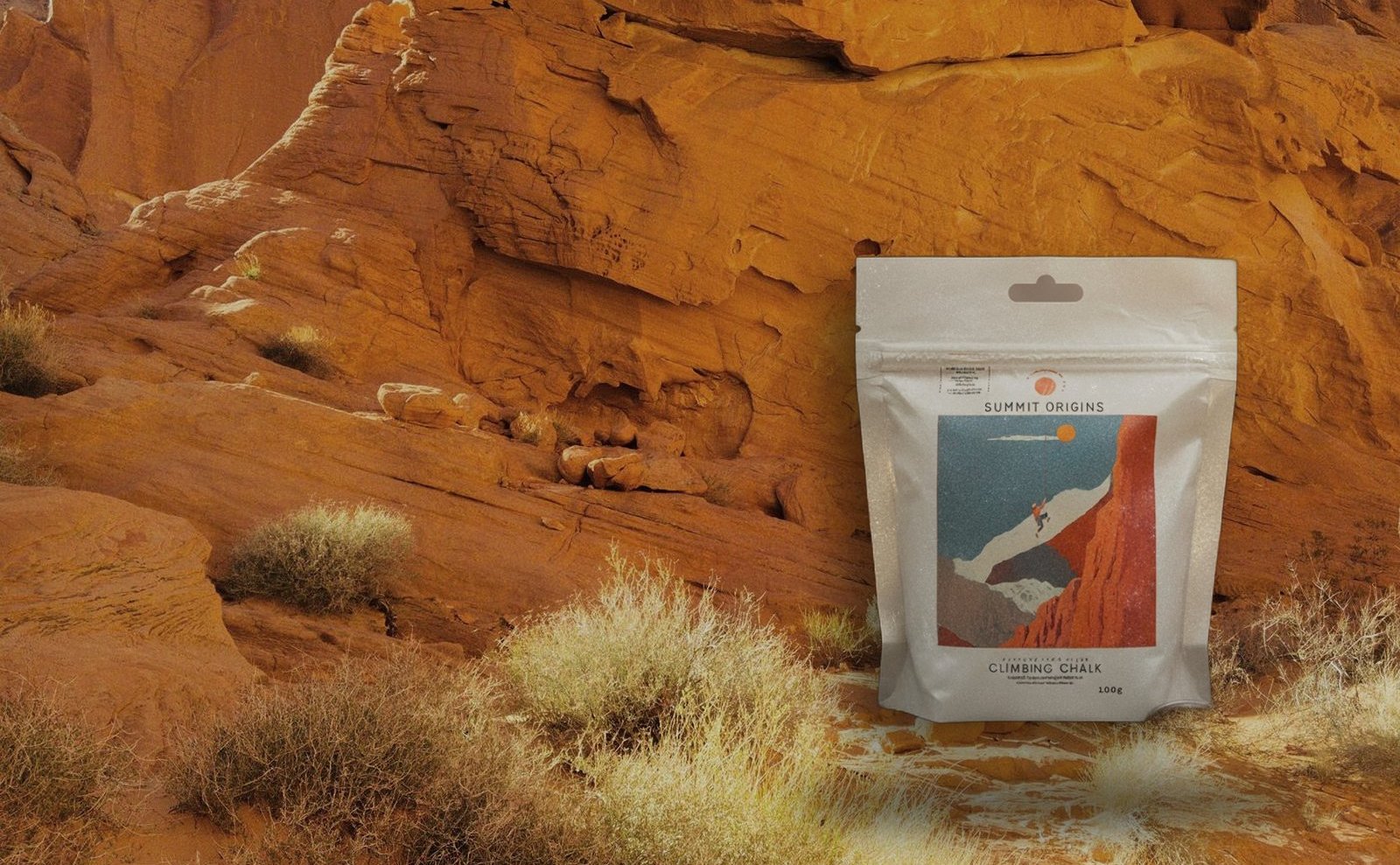 Bolsa de magnesia Chalk 01 de Summit Origins apoyada en una pared de roca naranja